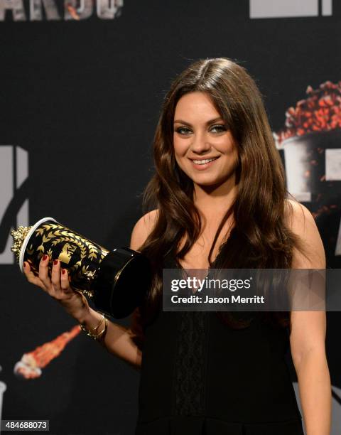 Actress Mila Kunis poses with the Best Villain award for 'Oz The Great and Powerful' in the press room during the 2014 MTV Movie Awards at Nokia...