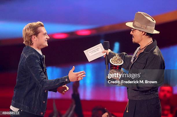 Actor Josh Hutcherson accepts the Movie of the Year award for 'The Hunger Games: Catching Fire' from actor Johnny Depp onstage at the 2014 MTV Movie...