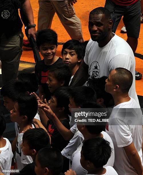 Superstar LeBron James of the US poses for photos with young boys as he visits a government mass housing project as part of the clinic session in...