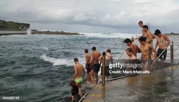 Swans players walk into the ocean during a Sydney Swans AFL recovery session at Clovelly Beach on April 14, 2014 in Sydney, Australia.