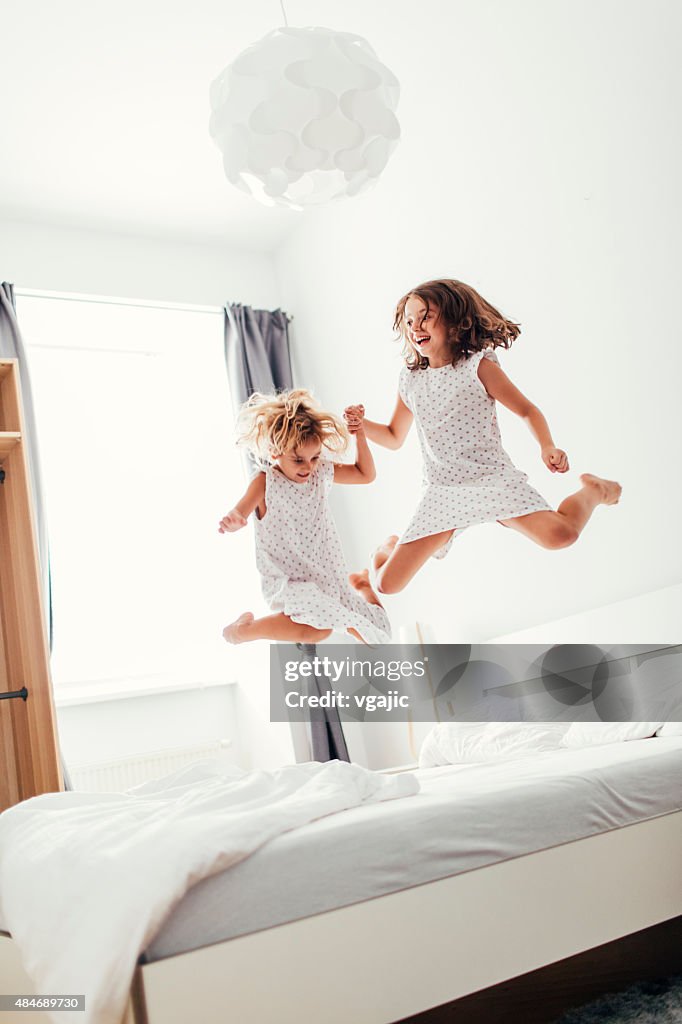 Sisters Jumping On The Bed.
