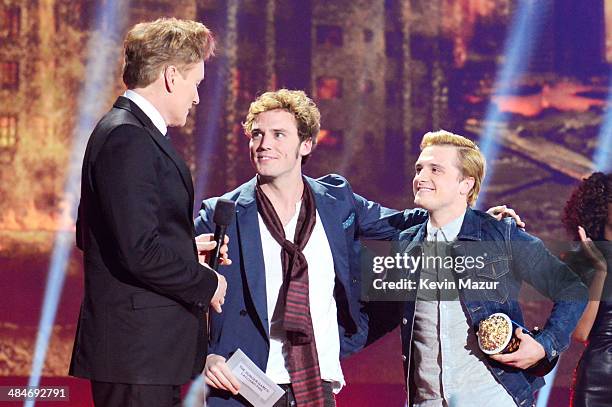 Host Conan O'Brien with actors Sam Claflin and Josh Hutcherson, winners of the Movie of the Year award for 'The Hunger Games: Catching Fire,' speak...