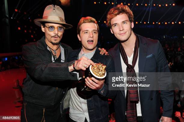 Actor Johnny Depp poses with actors Josh Hutcherson and Sam Claflin, winners of the Movie of the Year award for 'The Hunger Games: Catching Fire,' at...