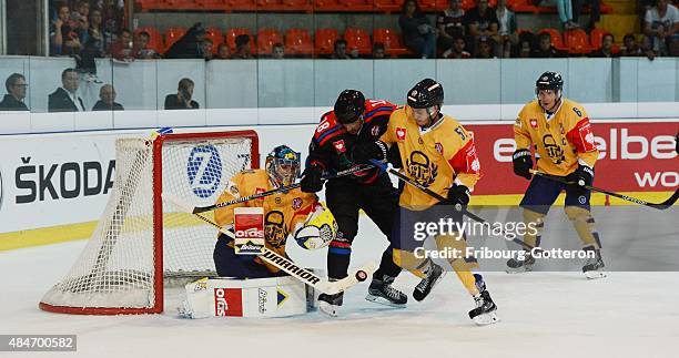 Goalkeeper Ryan Zapolski of Lukko Rauma and his team-mate Jesse Virtanen tussle with John Fritsche of Fribourg-Gotteron during the Champions Hockey...