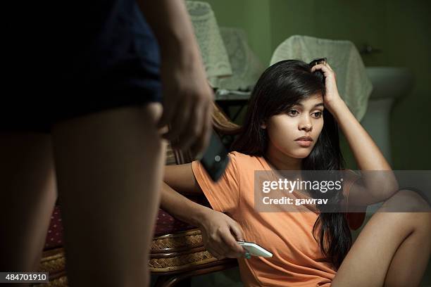 indoor, sad asian girl holding her head and mobile phone. - dorm daze 2 stock pictures, royalty-free photos & images
