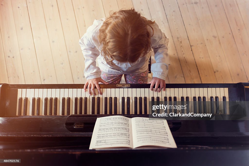 Vue aérienne de la jeune fille jouant du Piano à la lumière de la chambre