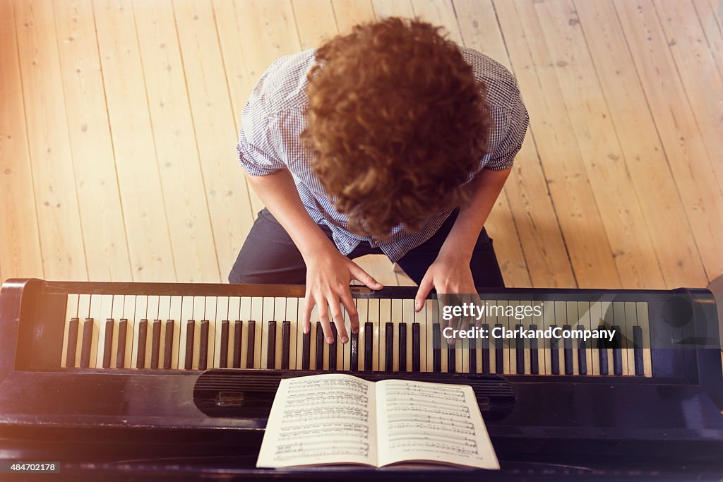 Overhead View of Teenage Boy Playing Piano In Sunlight Room