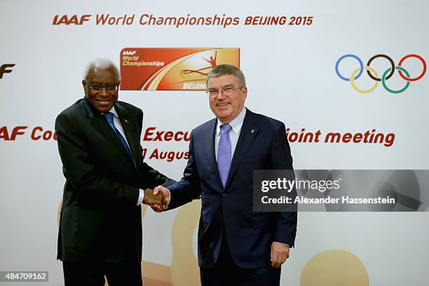 President Thomas Bach poses with IAAF President Lamine Diack after the media during a press conference after the IAAF Council and IOC Executive Board...