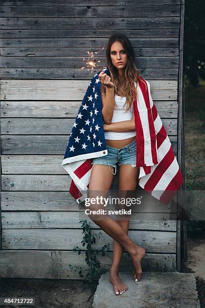 young woman with american flag. - american flag fireworks stock pictures, royalty-free photos & images