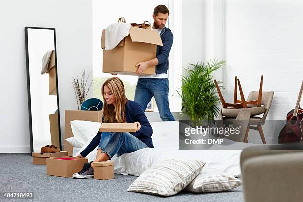 giovane coppia in movimento nella loro nuova casa - arrangiare foto e immagini stock