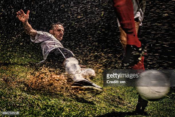 soccer players in action - tackling stockfoto's en -beelden