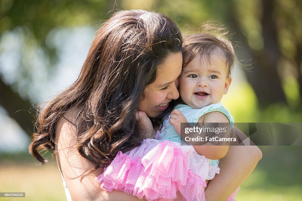 Jovem mãe abraçar seu bebê ao ar livre
