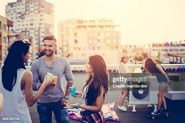 friends on a rooftop party - wegwerpbeker stockfoto's en -beelden