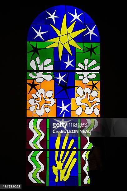 Gallery assistant poses with "Nuit de Noel", a stained glass artwork by Henri Matisse at the "Henri Matisse: The Cut-Outs" exhibition at the Tate...