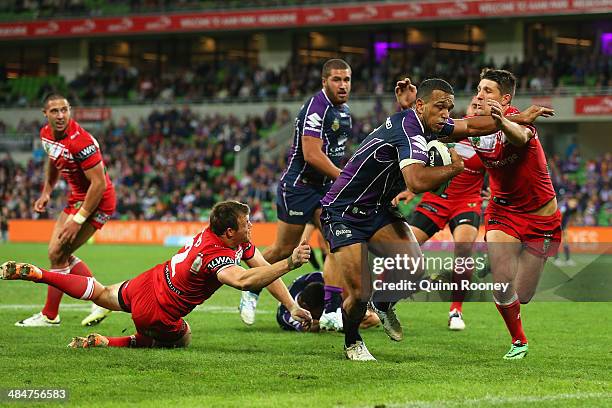 Will Chambers of the Storm breaks through a tackle by Gareth Widdop of the Dragons to score a try during the round 6 NRL match between the Melbourne...