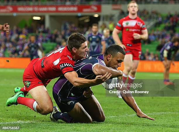 Will Chambers of the Storm breaks through a tackle by Gareth Widdop of the Dragons to score a try during the round 6 NRL match between the Melbourne...