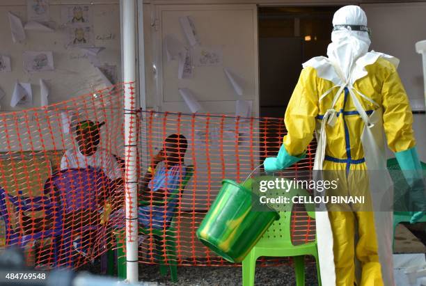 Health worker walks towards patients under quarantine at the Nongo ebola treatment centre in Conakry, Guinea on August 21, 2015. The World Health...