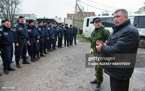 Man, who introduced himself as a lieutenant colonel of the Russian army, speaks to policemen as he introduces his appointed new head of the regional...