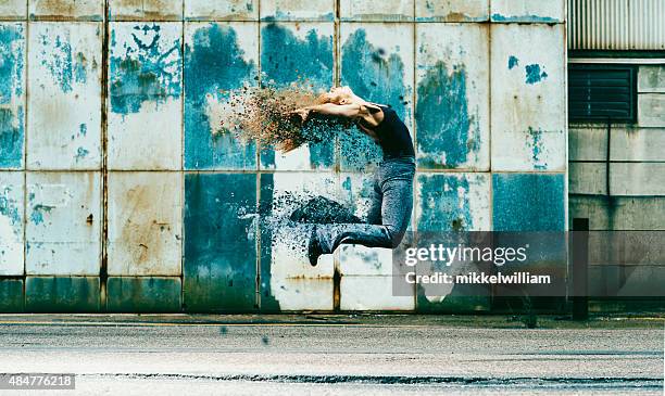 woman jumps into the air and her body dissolves - changing form stock pictures, royalty-free photos & images