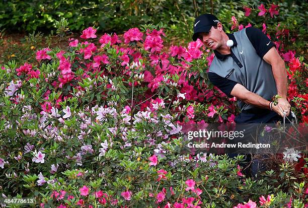 Rory McIlroy of Northern Ireland hits a shot out of the the azalea bushes behind the 13th green during the second round of the 2014 Masters...