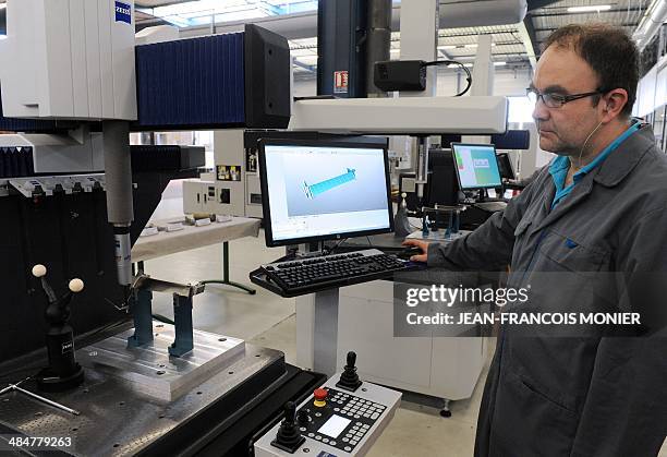 Mecachrome employee checks a TiAi turbine blade for the new jet engine LEAP of SNECMA , on April 14, 2014 at the Mecachrome plant in...