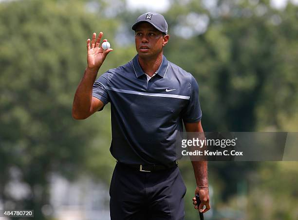 Tiger Woods reacts after a birdie putt on the third green during the second round of the Wyndham Championship at Sedgefield Country Club on August...