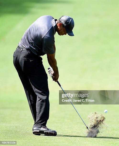 Tiger Woods plays from the fairway on the ninth hole during the second round of the Wyndham Championship at Sedgefield Country Club on August 21,...