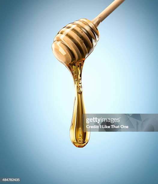 honey spoon with pure honey - honinglepel stockfoto's en -beelden