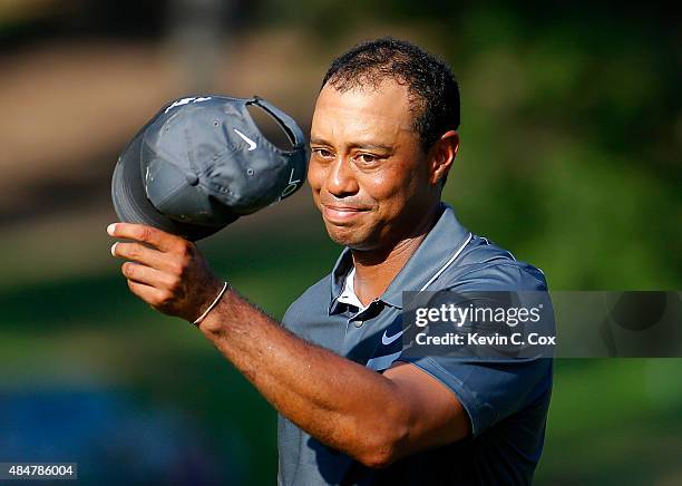 Tiger Woods reacts after his par putt on the 18th green during the second round of the Wyndham Championship at Sedgefield Country Club on August 21,...