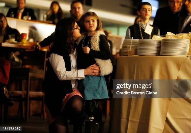 Denise Richard comforts her daughter, Jane Richard, as a video showing images of of the 2013 Boston Marathon race before the bombing plays during a...