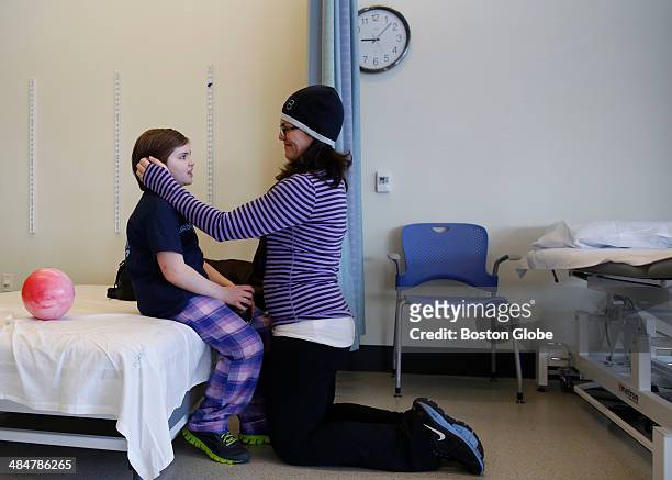 Denise Richard smoothes her daughter Jane's hair following a check up at Spaulding in Charlestown on February 10, 2014. The Richards brought Jane to...