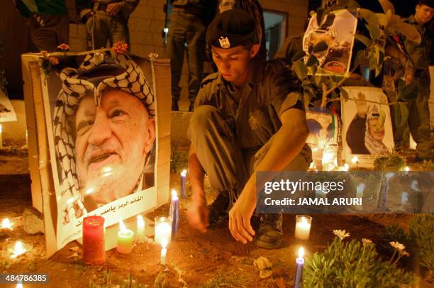 Palestinians soldiers light candles inside the Muqataa' compound on the eve of Veteran Palestinian leader Yasser Arafat's funeral 11 November 2004 in...