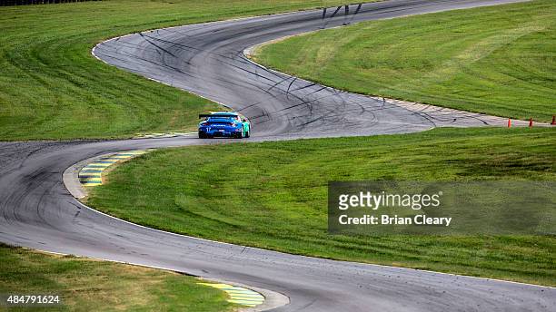 The Porsche 911 RSR of Wolf Henzler and Bryan Sellers races through the esses during practice for the IMSA Tudor Series GT race at Virginia...