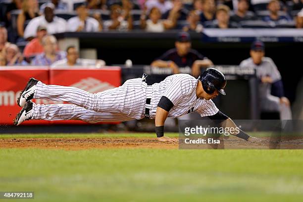 Carlos Beltran of the New York Yankees leaps back to touch home plate to score a run in the fourth inning against the Cleveland Indians on August 21,...