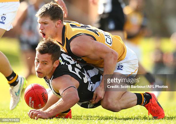 Ben Moloney of Collingwood is tackled by Matthew Arnot of Richmond during the round 19 VFL match between Collingwood and Richmond at Victoria Park on...