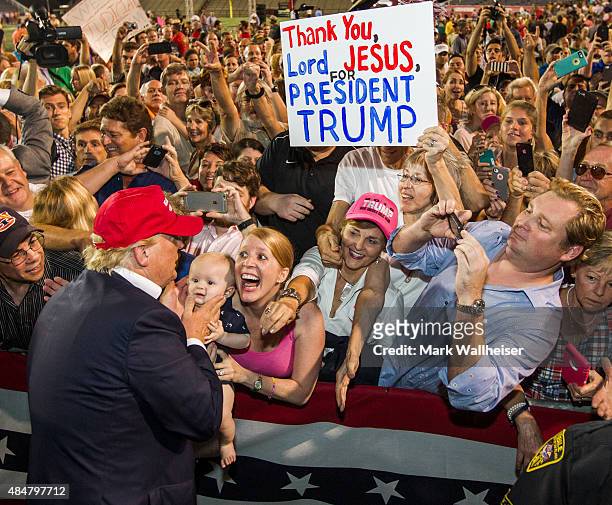 Republican presidential candidate Donald Trump greets supporters after his rally at Ladd-Peebles Stadium on August 21, 2015 in Mobile, Alabama. The...