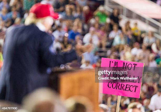 Supporter holds up a sign as Republican presidential candidate Donald Trump speaks during a rally at Ladd-Peebles Stadium on August 21, 2015 in...