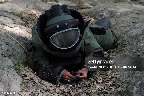 An Afghan National Army soldier participates in an IED defusing training exercise in Jalalabad, Nangarhar province on April 14, 2014. Afghans have...