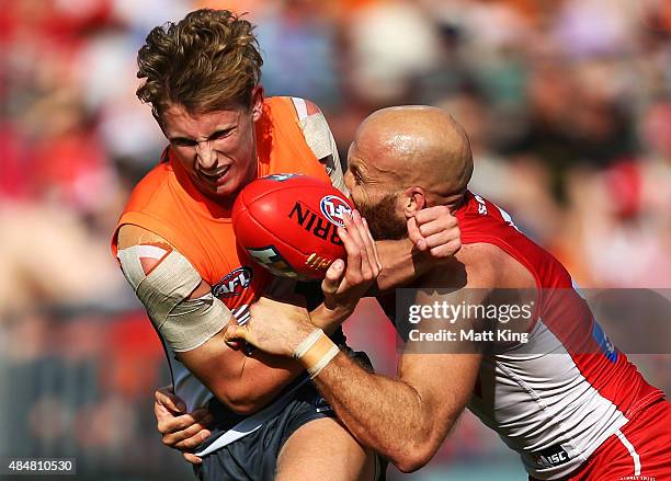 Lachie Whitfield of the Giants is tackled by Jarrad McVeigh of the Swans during the round 21 AFL match between the Greater Western Sydney Giants and...