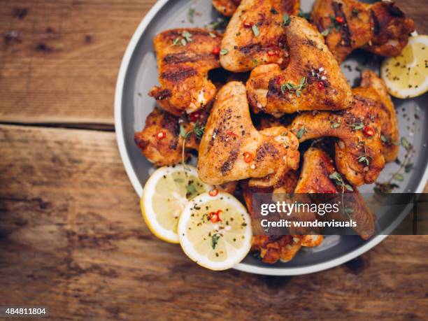 knusprige chillie bestreut chicken-wings auf teller - hähnchen grill stock-fotos und bilder