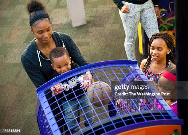 Washington Mystics guard Tayler Hill helps her son, Maurice Lighty, shoot hoops at Chuck E. Cheese's August 18, 2015 in Edina, MN. Since she's based...