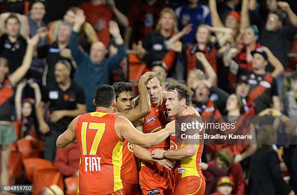 Tom Lynch of the Suns celebrates victory with team mates after the round 21 AFL match between the Gold Coast Suns and the Essendon Bombers at...