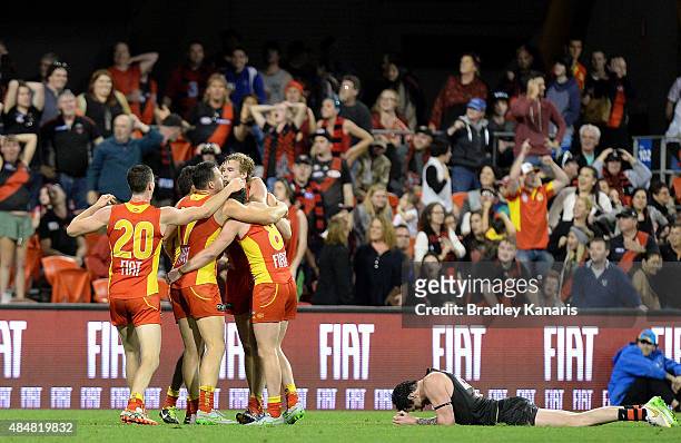 Tom Lynch of the Suns and team mates celebrate victory after the round 21 AFL match between the Gold Coast Suns and the Essendon Bombers at Metricon...