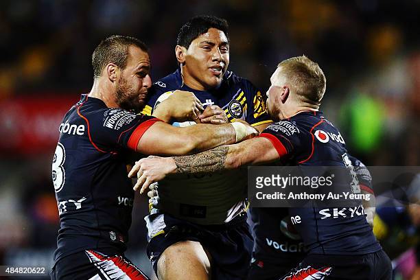 Jason Taumalolo of the Cowboys charges against Simon Mannering and Sam Tomkins of the Warriors during the round 24 NRL match between the New Zealand...