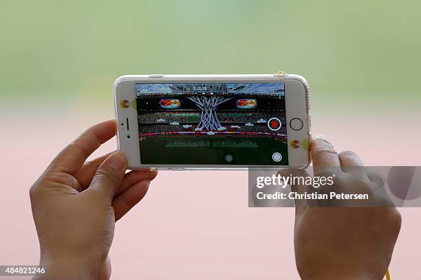 Spectator records a video on a smartphone of the Opening Ceremony for the 15th IAAF World Athletics Championships Beijing 2015 at Beijing National...