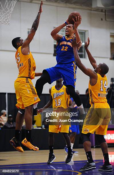 Lance Goulbourne of the Santa Cruz Warriors goes to the basket against Shawne Williams and C.J. Williams of the Los Angeles D-Fenders on April12,...