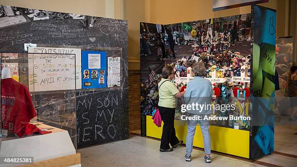 Women walk through an exhibit titled, "Dear Boston: Messages from the Marathon Memorial" in the Boston Public Library to commemorate the 2013 Boston...
