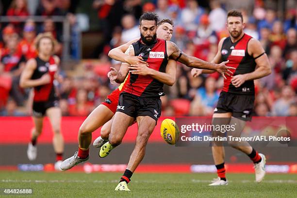 Kade Kolodjashnij of the Suns tackles Courtenay Dempsey of the Bombers during the round 21 AFL match between the Gold Coast Suns and the Essendon...