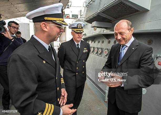 In this handout image provided by the U.S. Navy, Romanian President Traian Basescu speaks with Cmdr. Scott Jones, commanding officer of the Arleigh...