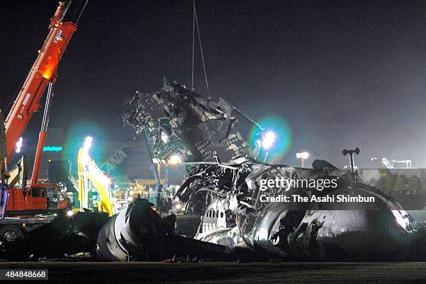 Workers remove the debris of crashed FedEx airplane 80 at Narita International Airport on March 24, 2009 in Narita, Chiba, Japan. The aircargo failed...